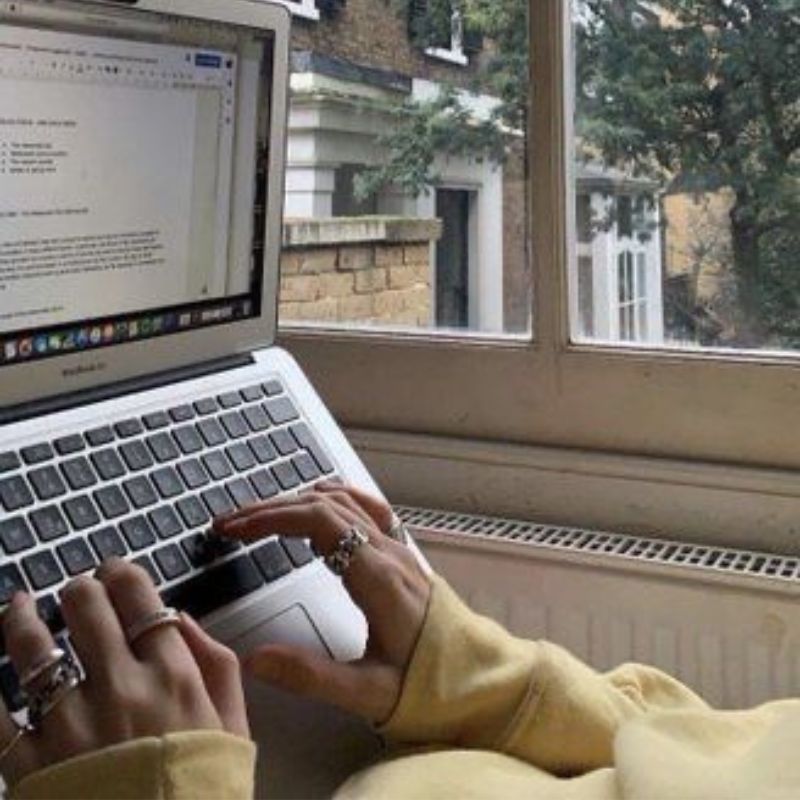 Fille tapant un texte sur son ordinateur